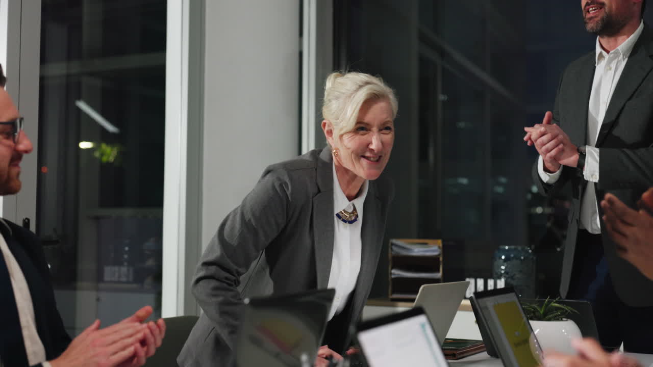 Donna d'affari che celebra il successo con il team in una riunione d'ufficio