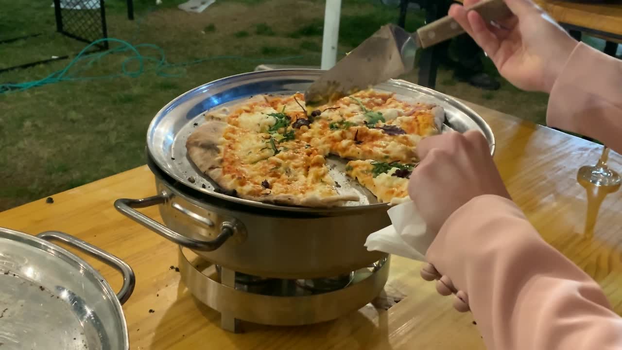 금속 스파라로 도자기 접시에 피자 조각을 가져가는 여자