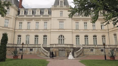 encantadores recién casados caucásicos novia y novio con ramo cerca del castillo, pareja de bodas primer encuentro