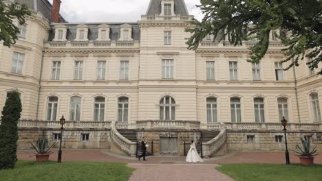 lovely newlyweds caucasian bride and groom with bouquet near castle, wedding couple first meeting