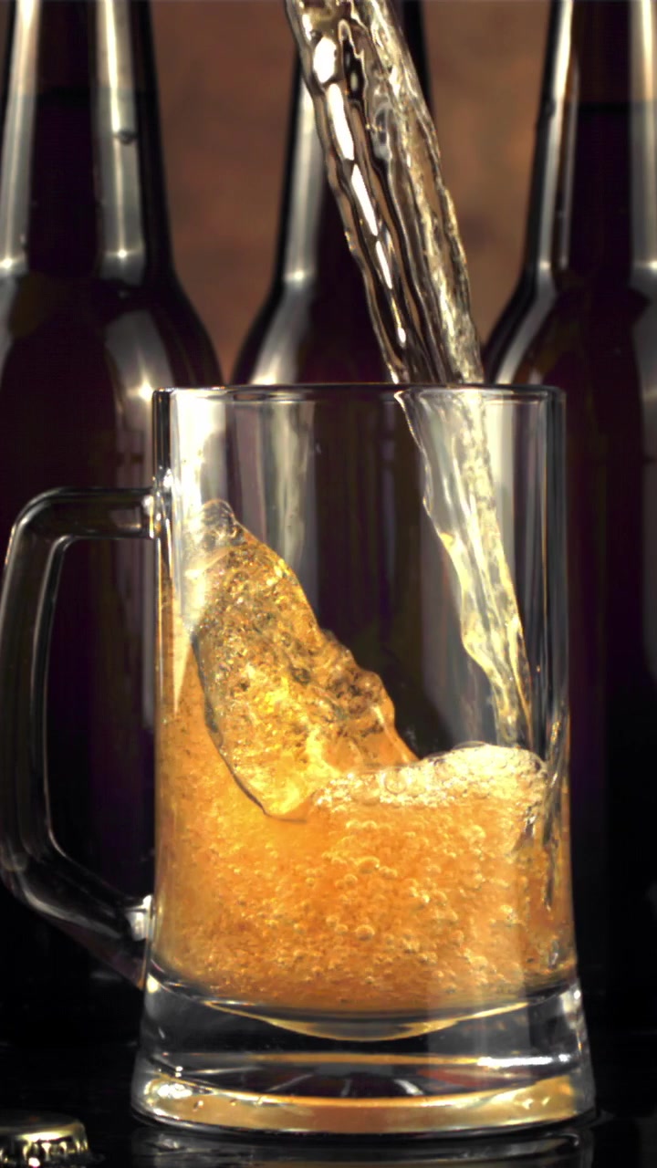 Birra dorata che si versa in un boccale di vetro al rallentatore