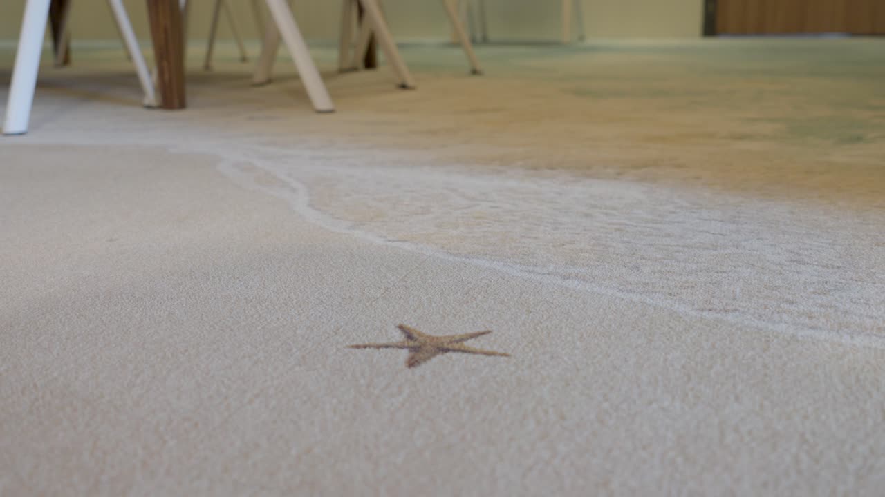 Low orbiting shot of a star imprint on a fake beach flooring in a house