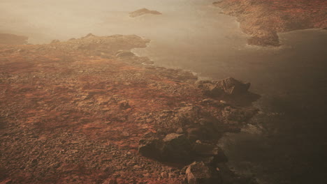 Clear-river-with-rocks-leads-towards-mountains-lit-by-sunset