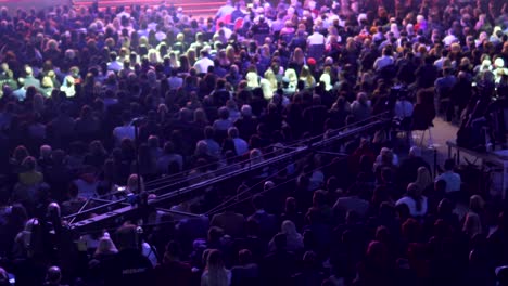 tv camera on a crane on football mach or concert with crowd of people