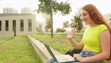 a young woman using a laptop in a park