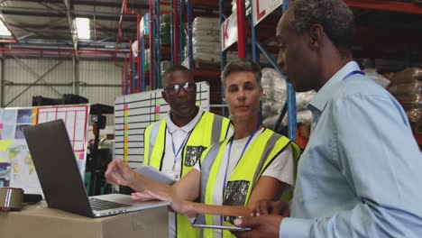 warehouse staff meeting around a laptop 4k