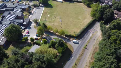 Aerial:-residential-area-with-field,-road-and-trees-at-Suffolk---drone-flying-forward-shot