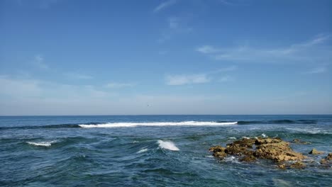 Waves-wash-over-a-reef-in-shallow-water-just-offshore-from-a-small-tropical-island