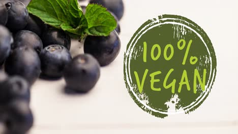 Animation-of-100-percent-vegan-text-in-green-over-fresh-organic-blueberries