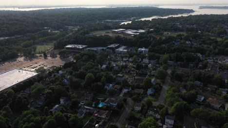 aerial flyover long island, ny suburban city with big box offices. bay in the distance. in 4k