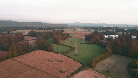 Transmission-Towers-With-Power-Lines-Situated-On-The-Fields-With-Crops-Near-The-Highway-In-Slovenia,-Europe