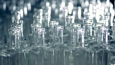 una pila de botellas de vidrio vacías se mueve hacia adelante y hacia los lados