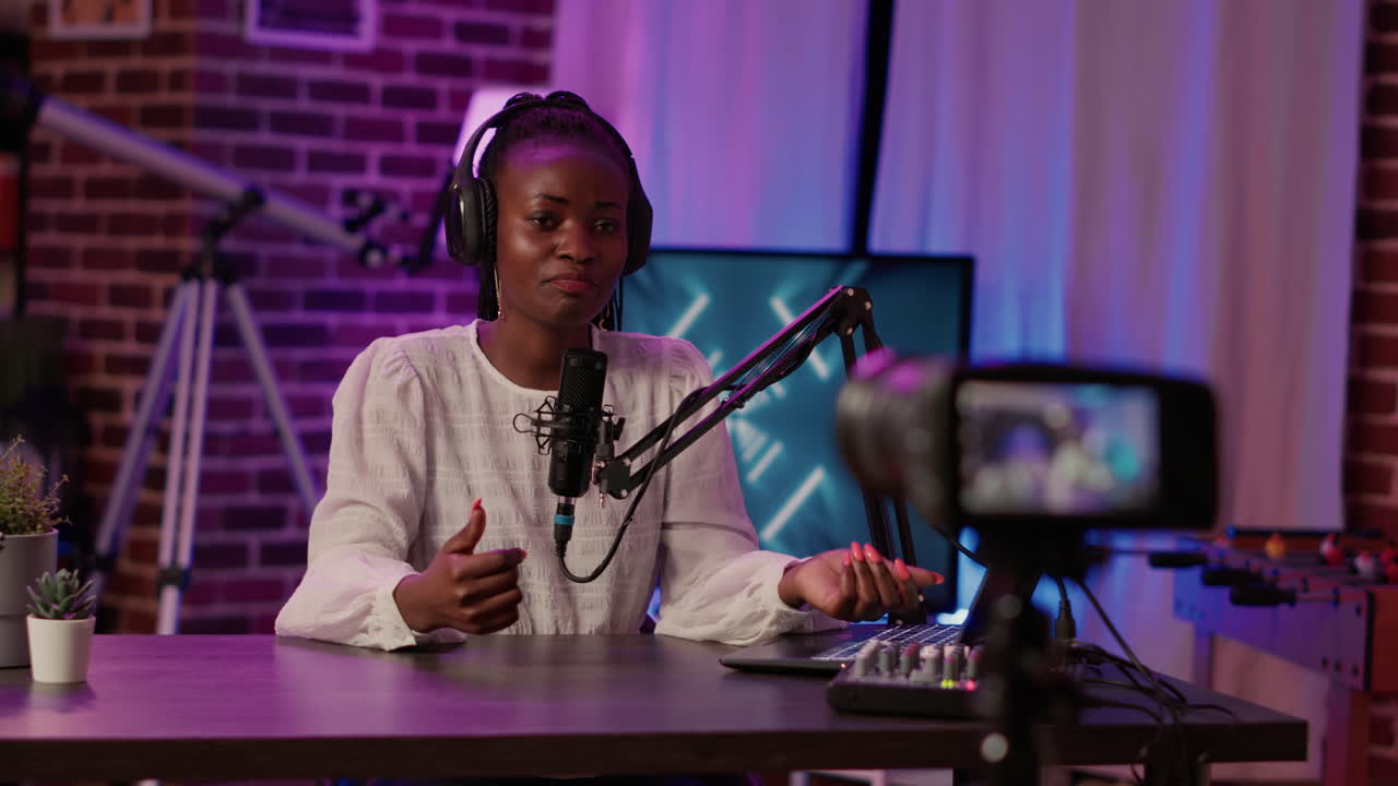 Selective focus on african american woman influencer talking in front of digital camera recording vlog