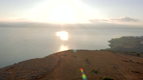 vista costera mientras la luz del sol llena el cielo y los rayos bajan desde los cielos reflejándose en el mar, creando luz volumétrica