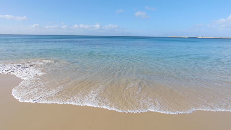 the beach and small waves next to naval base