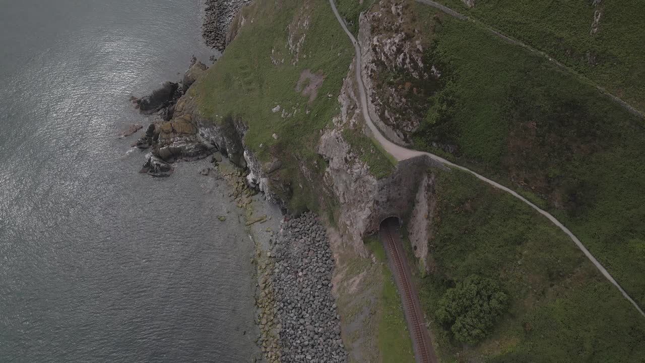 tren en el sendero del acantilado en bray, wicklow, irlanda - toma aérea