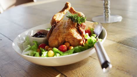 Video-of-healthy-appetising-meal-with-roast-chicken,-sauce-and-salad-on-wooden-dinner-table