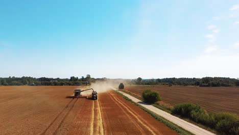 Toma-Aérea-De-La-Cosechadora-Cargando-Granos-De-Maíz-En-El-Remolque-Del-Tractor-2