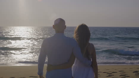 back view of couple in love looking at sea