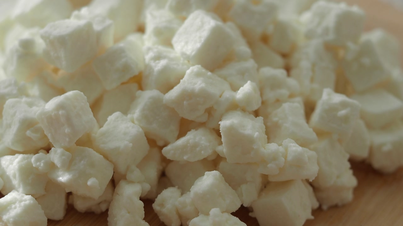 Close-Up of Fresh White Feta Cheese Cubes on a Wooden Board
