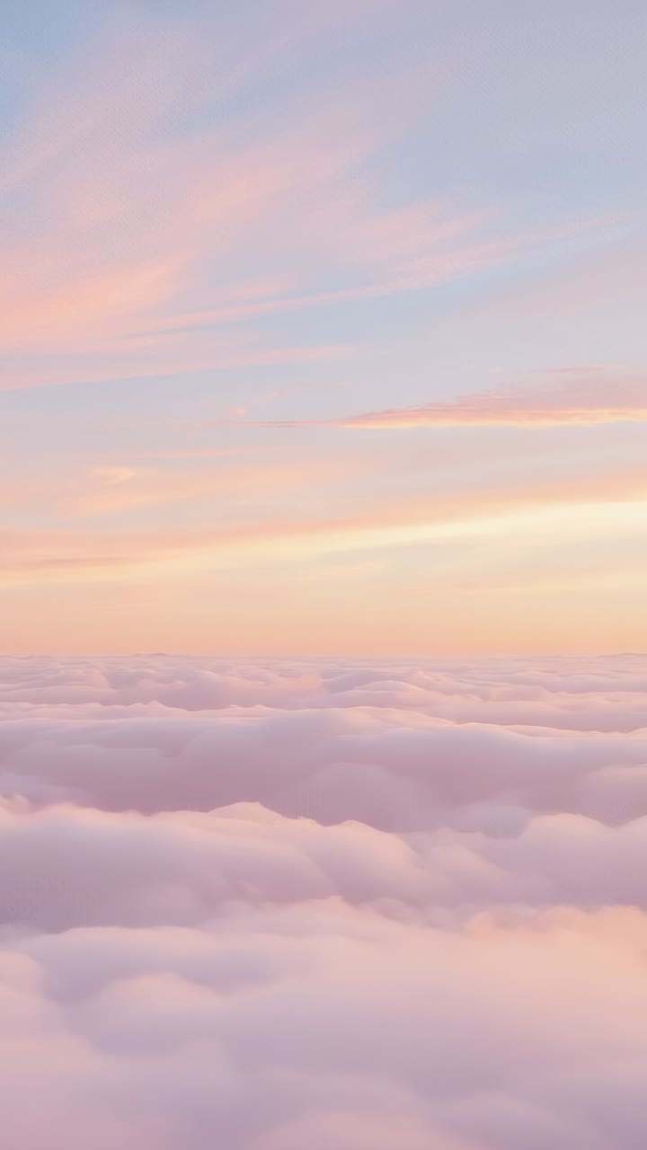 Vertical video: Sunrise light shifting across pastel cloud layer in drone view, creating ambience