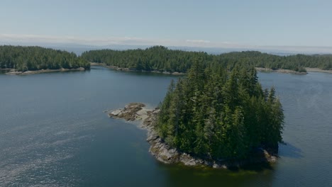 drone footage circling a small island in a bay on the pacific ocean near vancouver island, british columbia canada