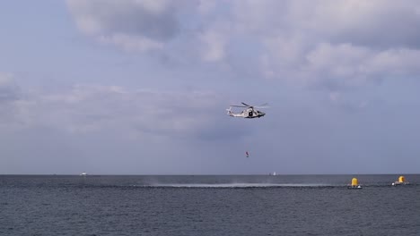 Shot-of-a-helicopter-rescuing-a-drowning-man-during-air-show-at-Malta-St-Paul's-Bay