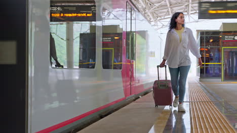 woman walking with suitcase at train station