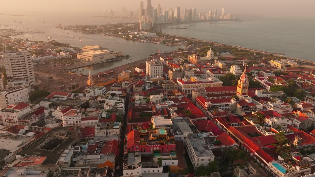 Drone revela o centro histórico de Cartagena, subindo para mostrar o moderno horizonte de Bocagrande ao nascer do sol sobre a costa caribenha