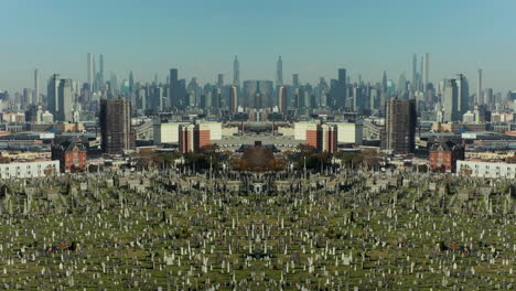 Forwards-fly-above-large-cemetery,-Manhattan-skyscrapers-in-background.-Abstract-computer-effect-digital-composed-footage