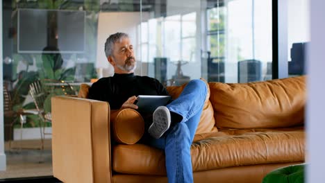 executive using laptop on sofa in office 4k
