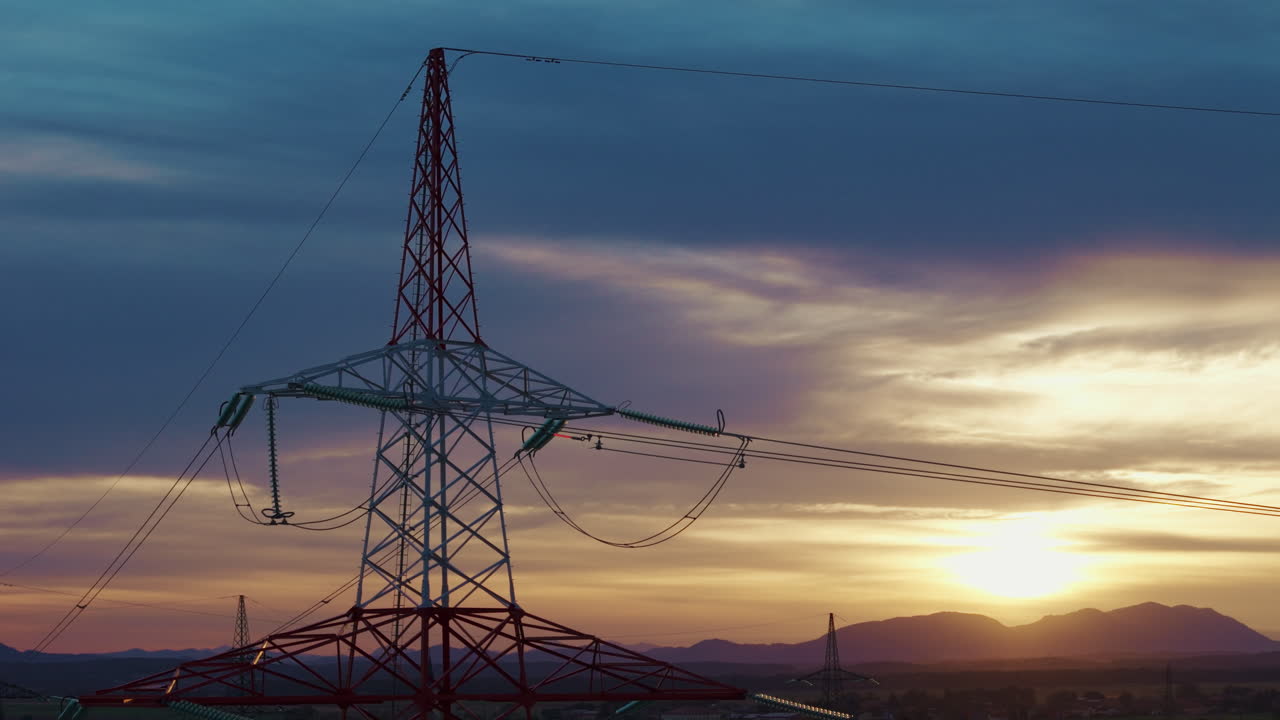 Power lines and transmission towers stand tall in a rural landscape during sunset connecting energy
