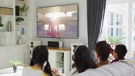 행복 한 가족 이 집 에서 함께 앉아 tv 에서 스포츠 이벤트 를 시청 하고 있는 사진