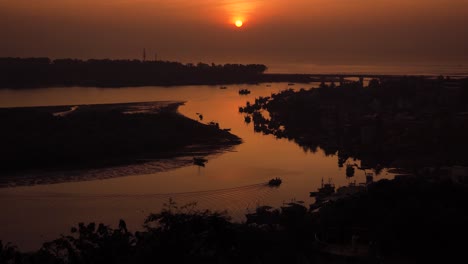 sunset over coastal village with fishing boats