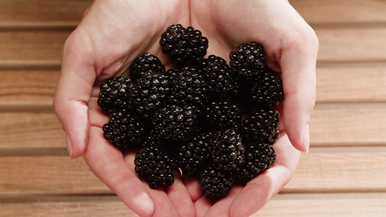 나무 테이블에 손에 블랙베리