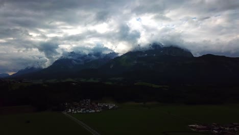 aerial shot above a mountain valley and a stormy cloudscape, oberndorf, austria