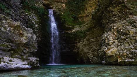 Lugar-Tranquilo-En-El-Cañón-Con-Cascada-Dentro-De-Altos-Acantilados-Y-Exuberante-Vegetación-En-Albania