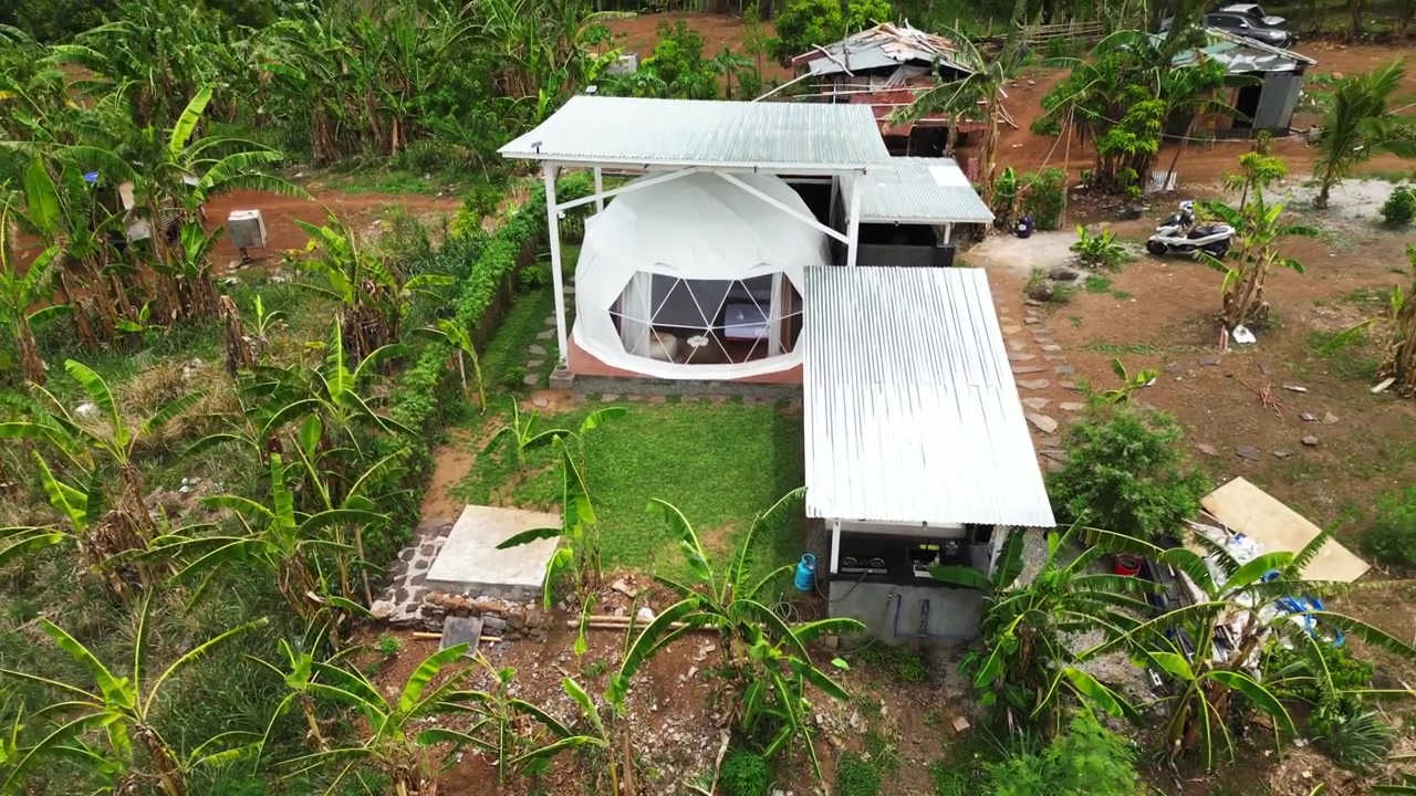 Cảnh quay từ trên cao giới thiệu một ngôi nhà mái vòm trên núi ở Tanay Rizal, Philippines, nằm gần sông Pililla với những ngọn đồi và cảnh quan rừng bao quanh.