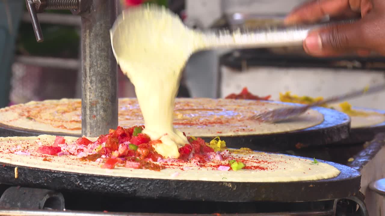 Street food vendors making savory dosa crepes, a traditional South Indian cuisine