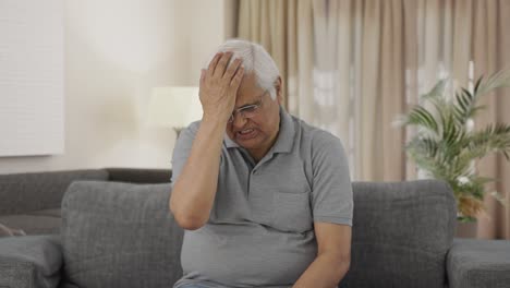 angry indian old man slapping his head