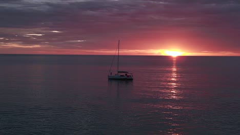 silhouette sailboat orange sun rays