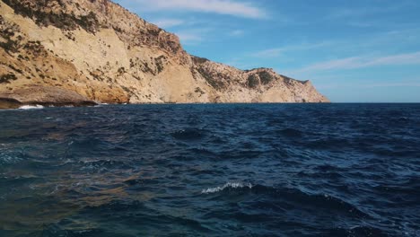 aerial-over-natural-infinity-pool-over-ocean-at-Sa-Pedrera-de-Cala-d'Hort,-Ibiza
