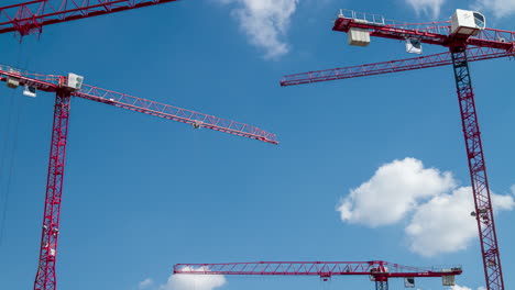 Time-lapse-of-red-moving-operating-cranes.-Low-angle