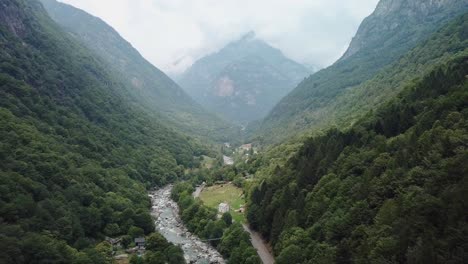 lush exotic green mountain valley road in valle verzasca, switzerland - aerial drone