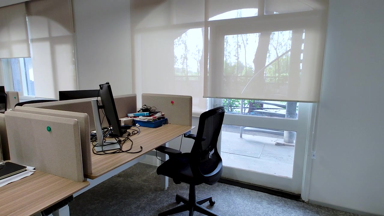 Postazione di lavoro moderna in ufficio aziendale con computer desktop, sedia ergonomica e luce naturale. Ideale per ambienti di lavoro, lavoro ibrido, produttività aziendale e concetti di interni per ufficio