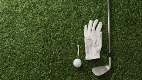 close up of golf club, ball and glove on grass, copy space, slow motion