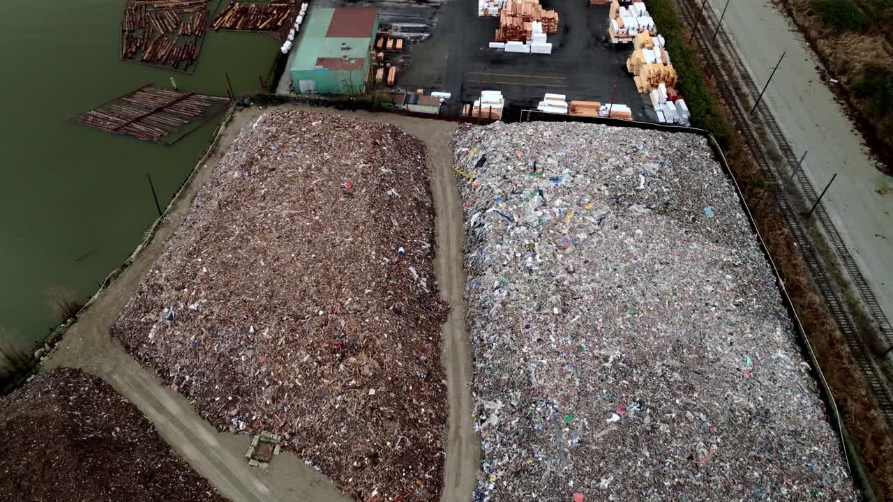Pile Of Waste At Recycling Transfer Station By The Fraser River In Canada. - aerial shot