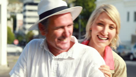 smiling couple sitting on a scooter