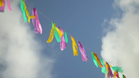 Colorful-Decorative-Banner-Against-Cloudy-Blue-Sky-On-Windy-Day