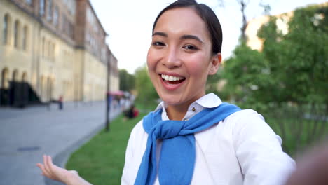 mujer alegre hablando con la cámara, haciendo una videollamada al aire libre